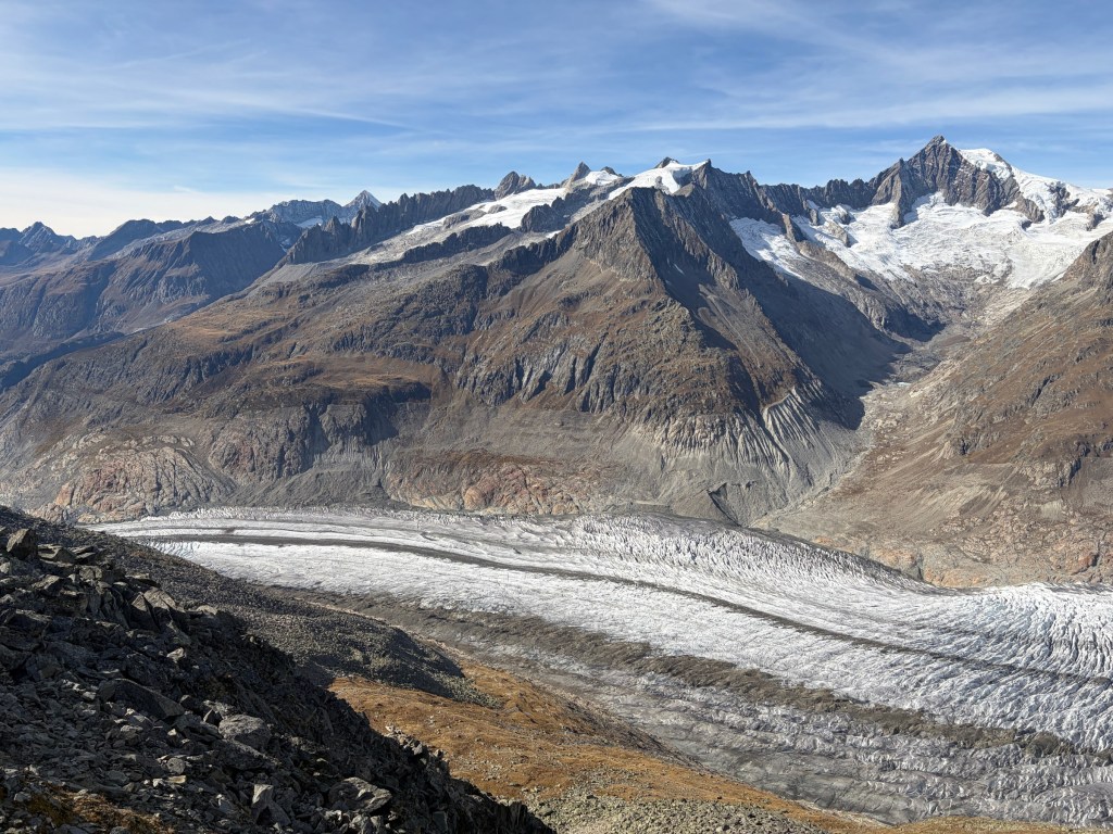 Aletsch Glacier curving beneath rocky Alpine peaks.