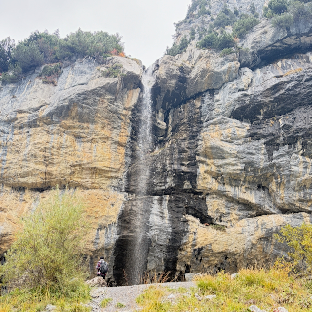 Waterfall descending a layered rock face