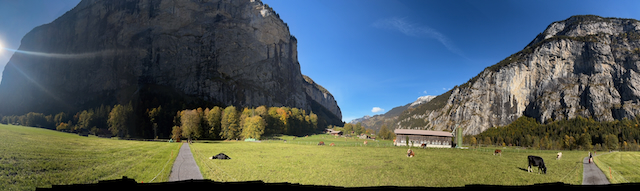 Wide meadow panorama beneath steep valley walls