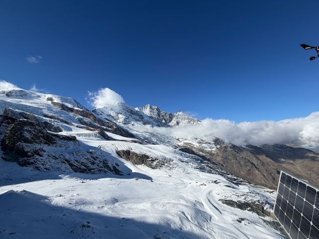 Snow-covered mountain slopes beneath a blue sky