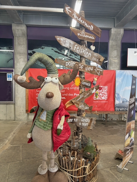 Playful alpine mascot beside wooden direction signs